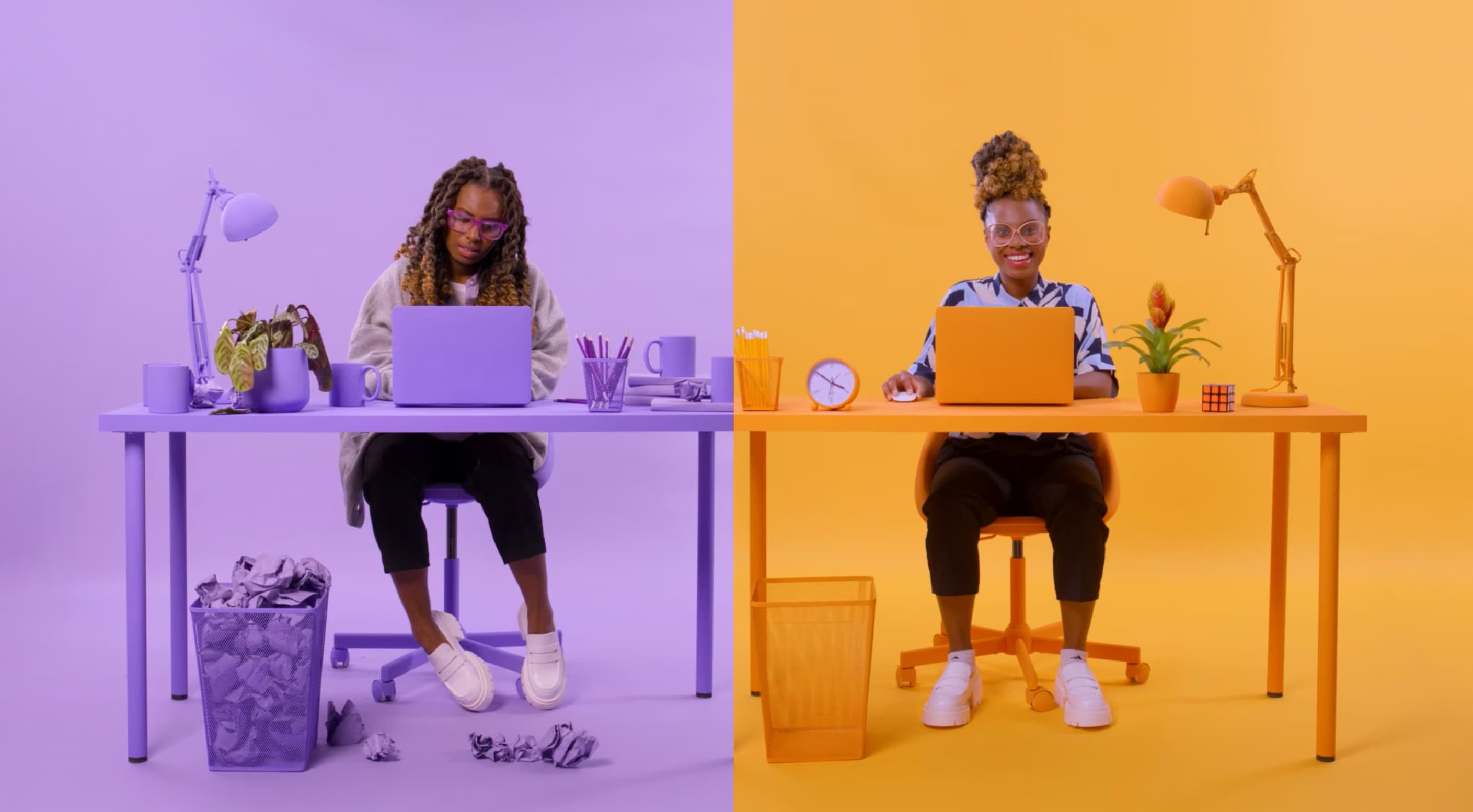 Two women using laptops in purple and orange art-directed studio sets for Awin