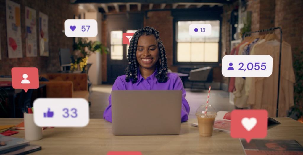 Woman using a laptop surrounded by animated social media icons
