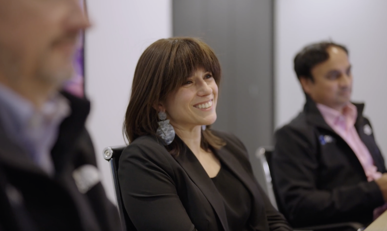 Brand video production planning meeting in a boardroom: team members smiling during a discussion about brand story and positioning