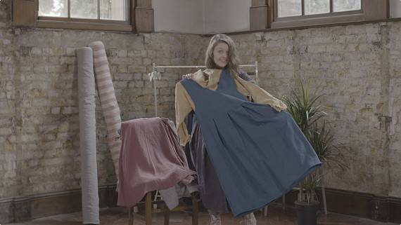 case study video featuring a female designer holding up a linen dress