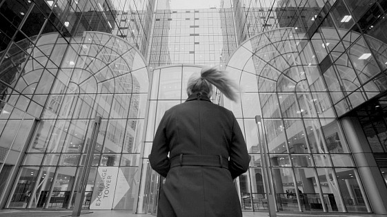 Woman walking into large corporate office