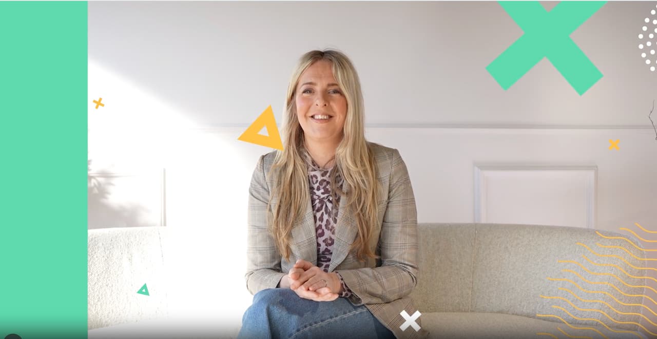 Woman seated in a corporate setting speaking to camera during a filmed interview