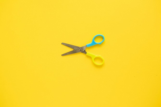 scissors open on yellow background