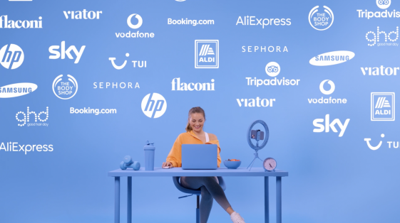 girl at desk with lots of brands behind her