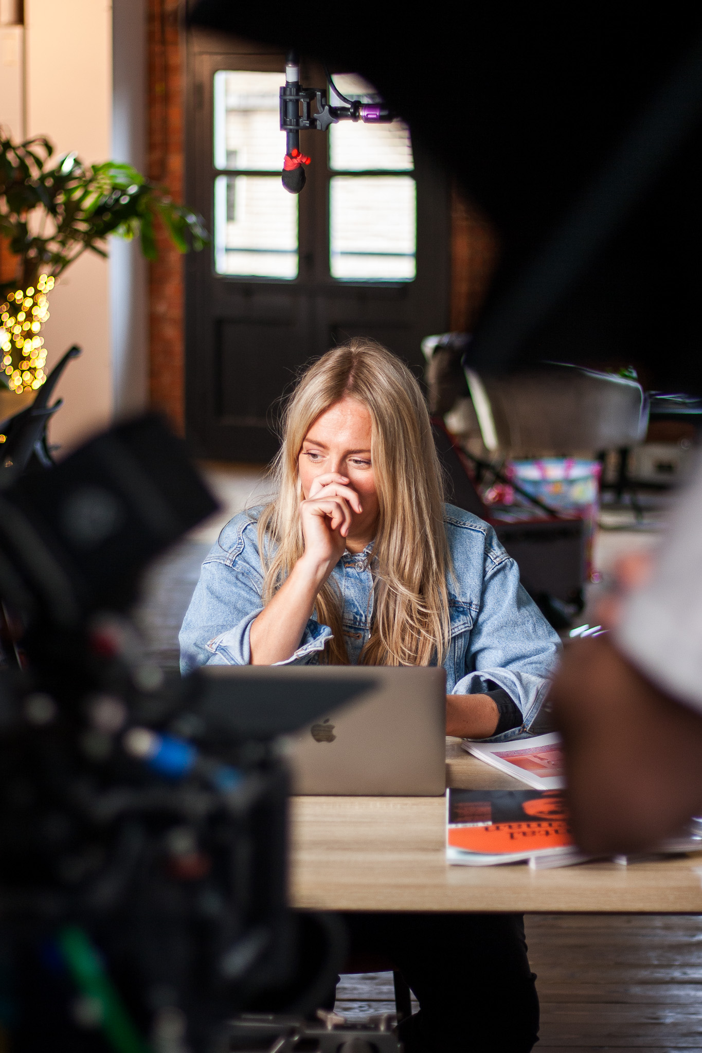 Woman deep in thought sitting at desk in modern office with laptop