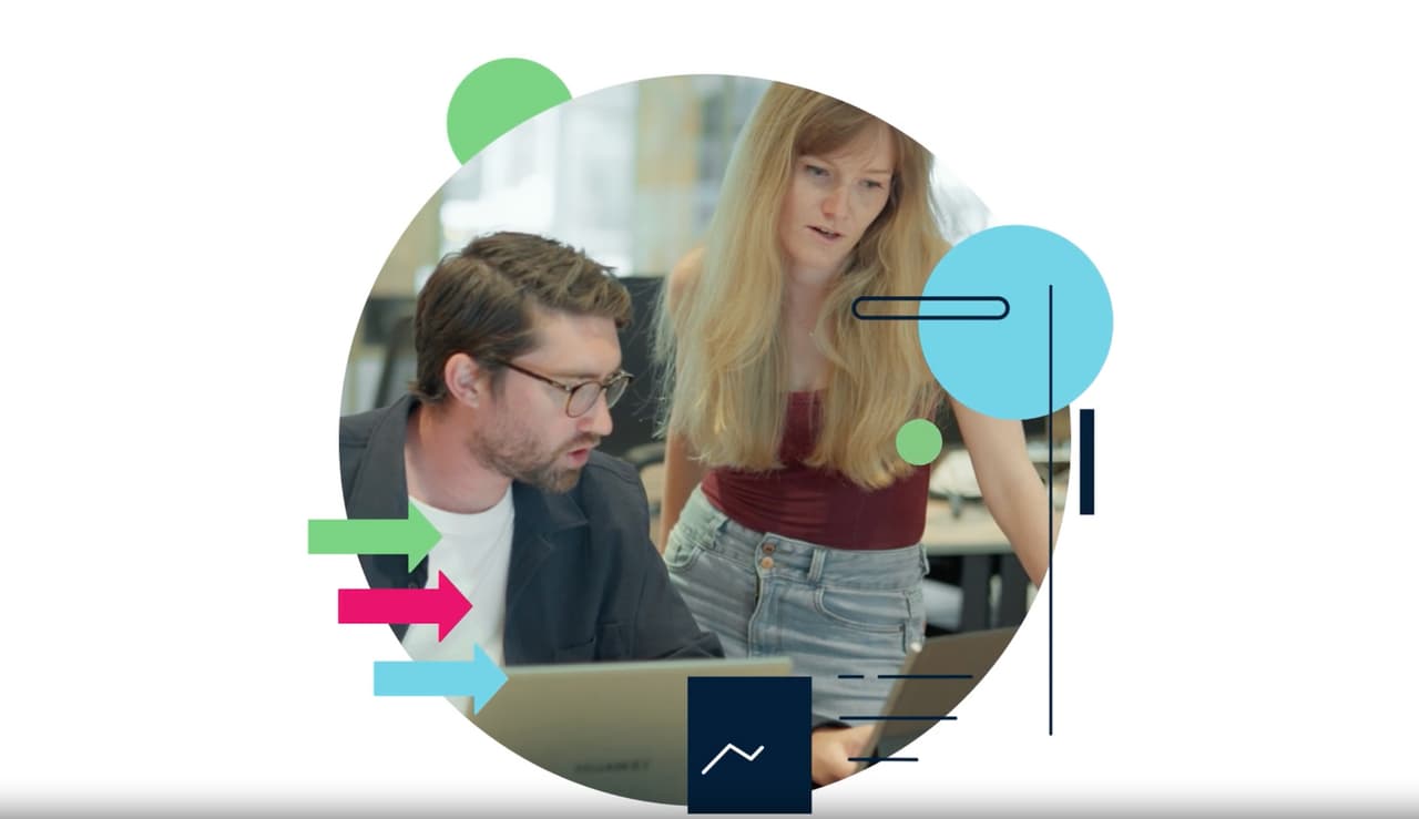 Man and woman looking at a laptop together in an office
