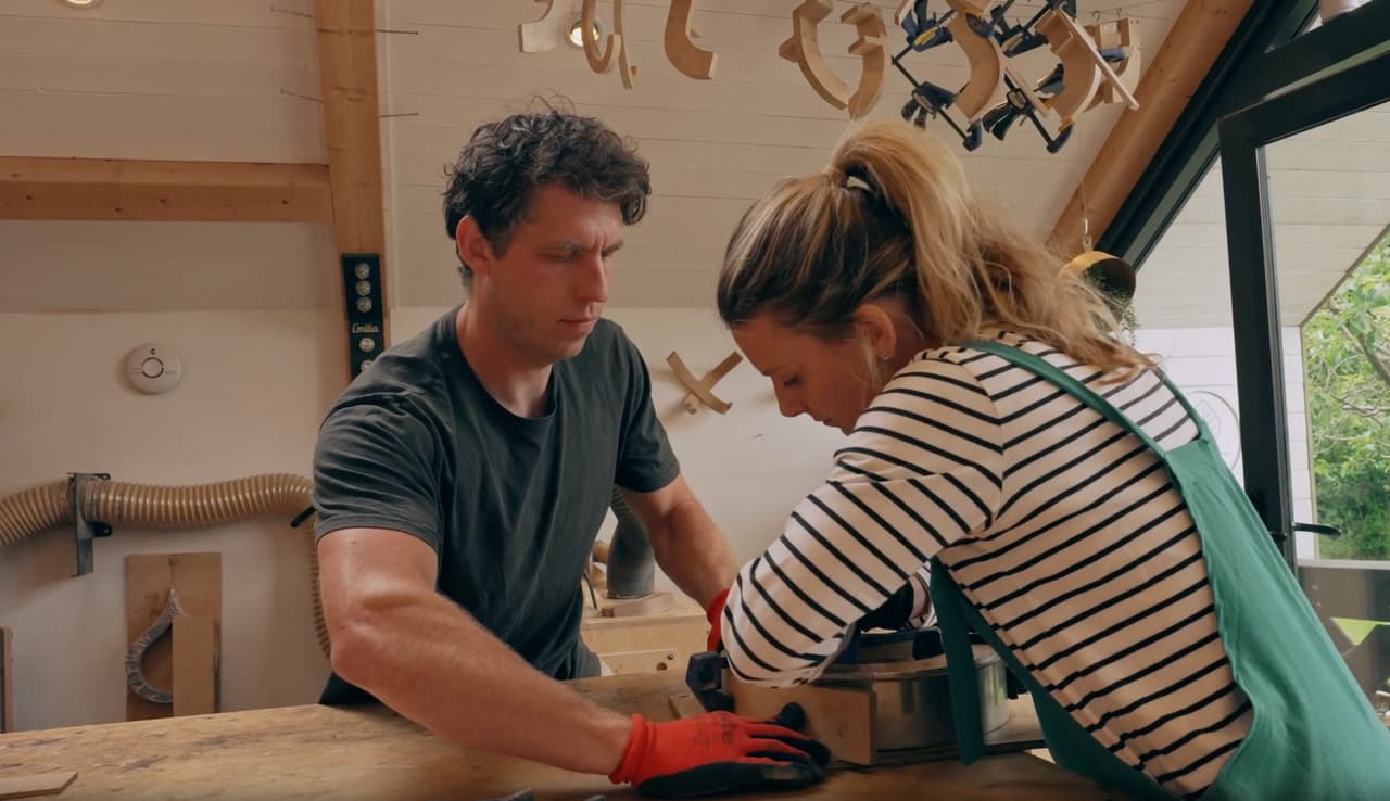 Two Etsy makers shaping wood together in their studio