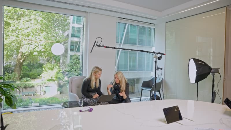 Two female leaders at Evelyn Partners discussing work together at a laptop during recruitment video filming