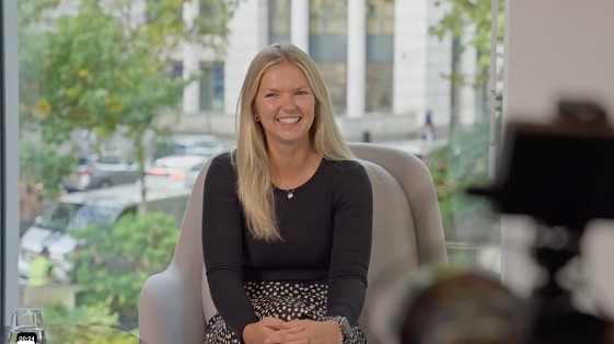 Evelyn Partners employee smiling during an EVP video interview with a camera in the foreground