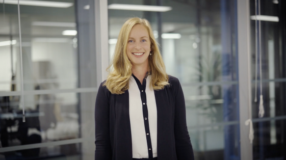 female with blonde hair smiling in an office environment
