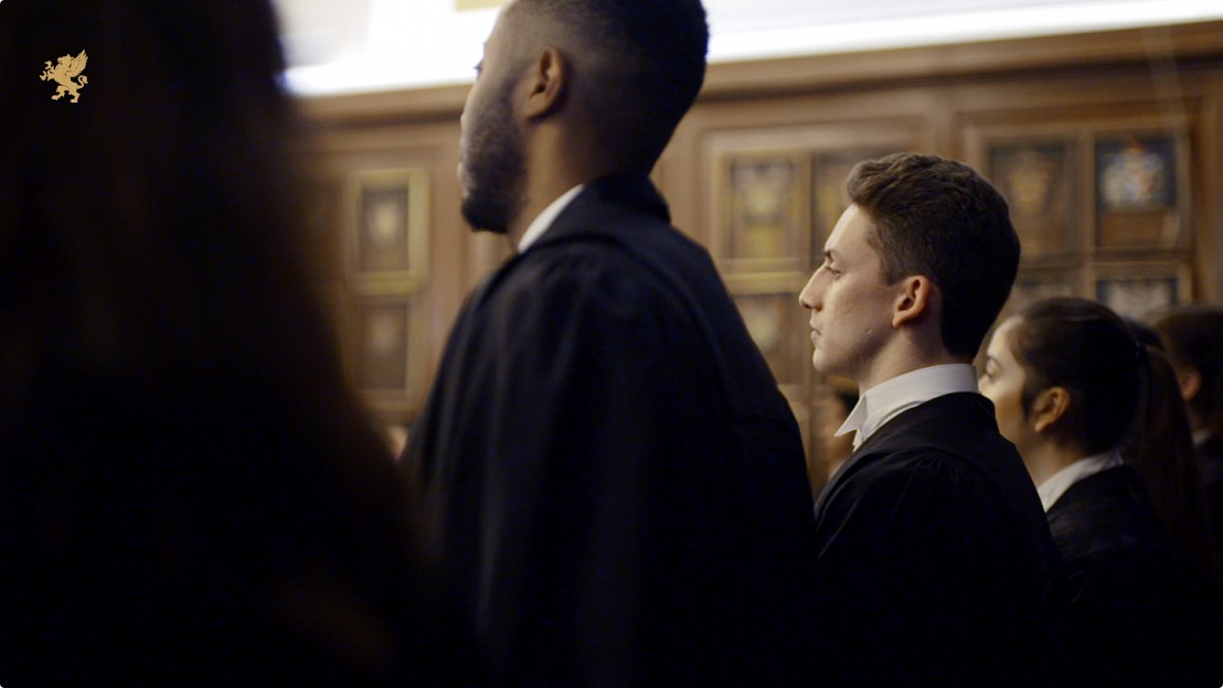 Line of young barristers phtographed wearing their robes from behind