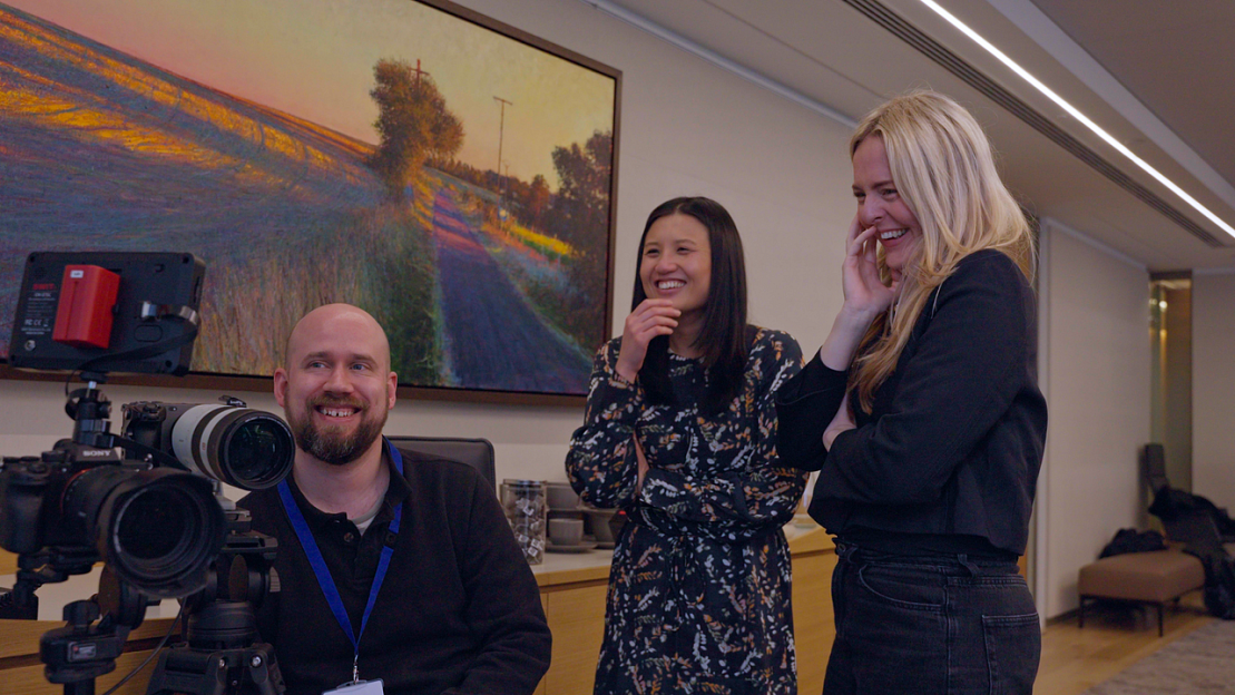 3 people from video production company smiling looking into camera monitor