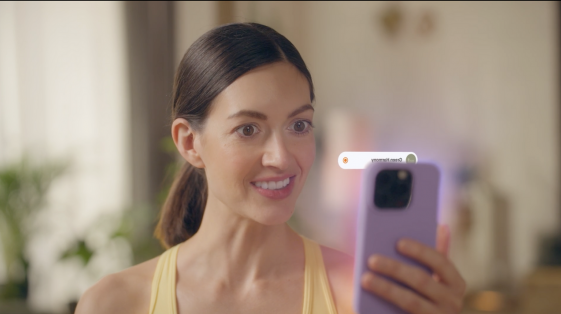 Smiling woman in workout gear holds a smartphone with an animated progress bar overlay, suggesting real-time tracking or app interaction in a SaaS product demo.