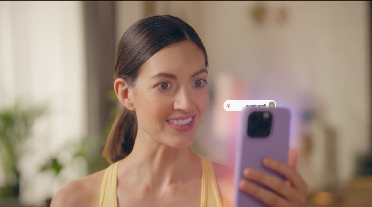 Publisher checking her phone as an animated Awin campaign alert appears