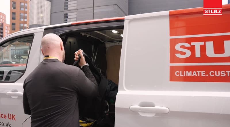 STULZ team member beside a branded service vehicle during customer testimonial filming