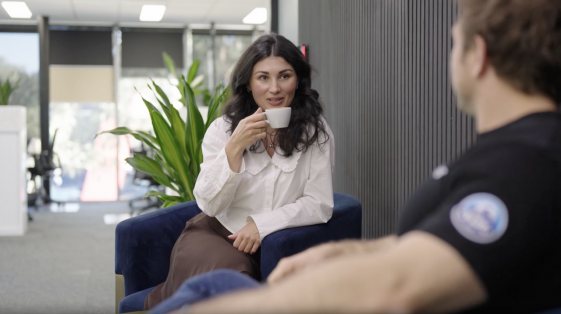 Team member holding a cup while being interviewed for an employer brand video